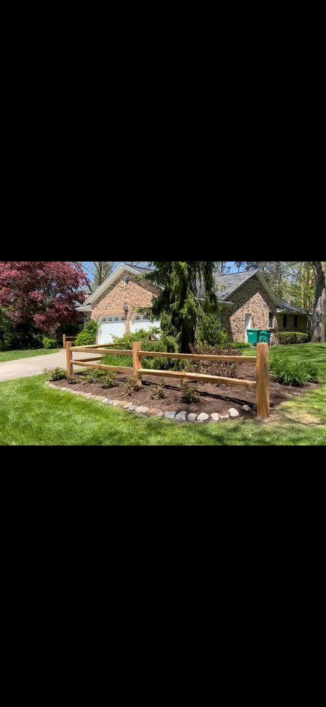 Split rail fence installed in a landscaped residential yard